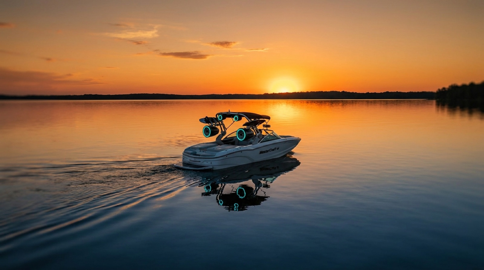 Wake boat at sunset with glowing teal LED tower speakers installed by Soundwaves
